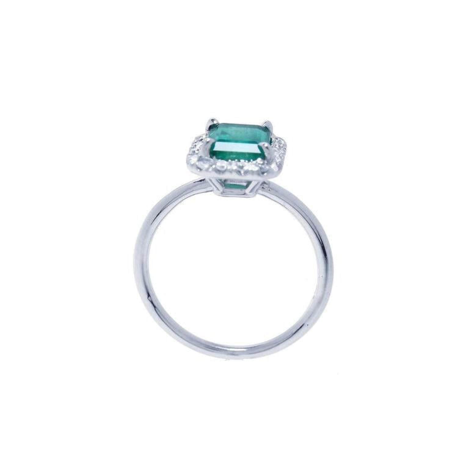 Emerald-cut Muzo emerald halo diamond ring in 14K white gold.