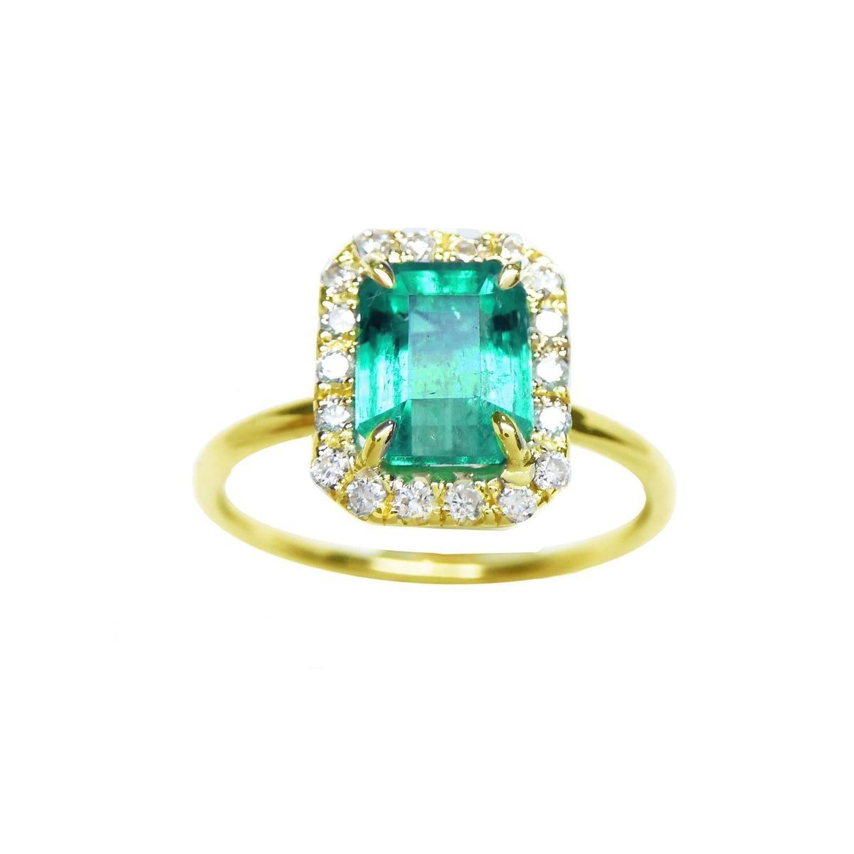 A rectangular emerald encircled into a halo diamond ring topside view.