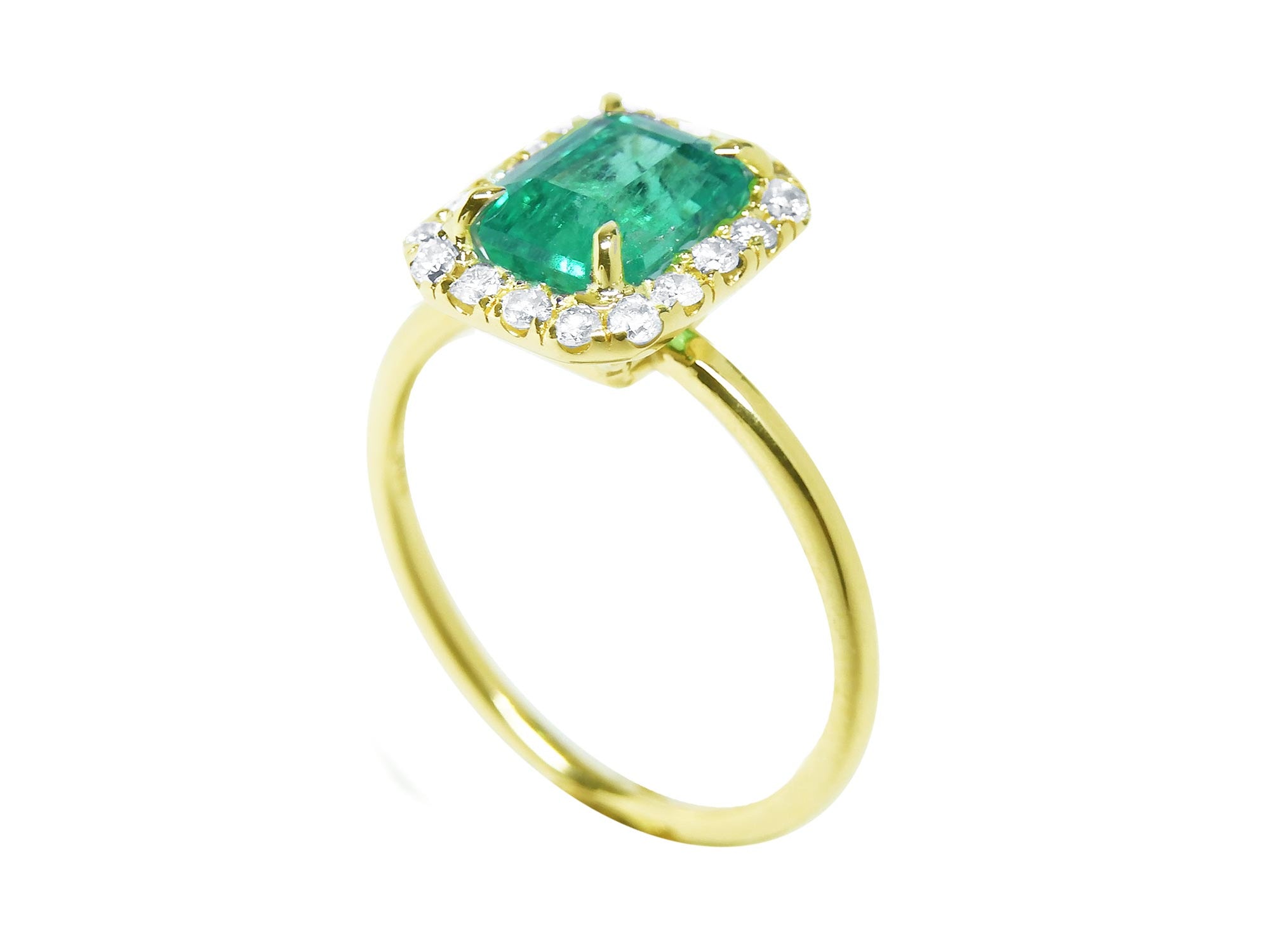 An emerald-cut halo diamond emerald ring in half side position, top setting and band profile displayed.