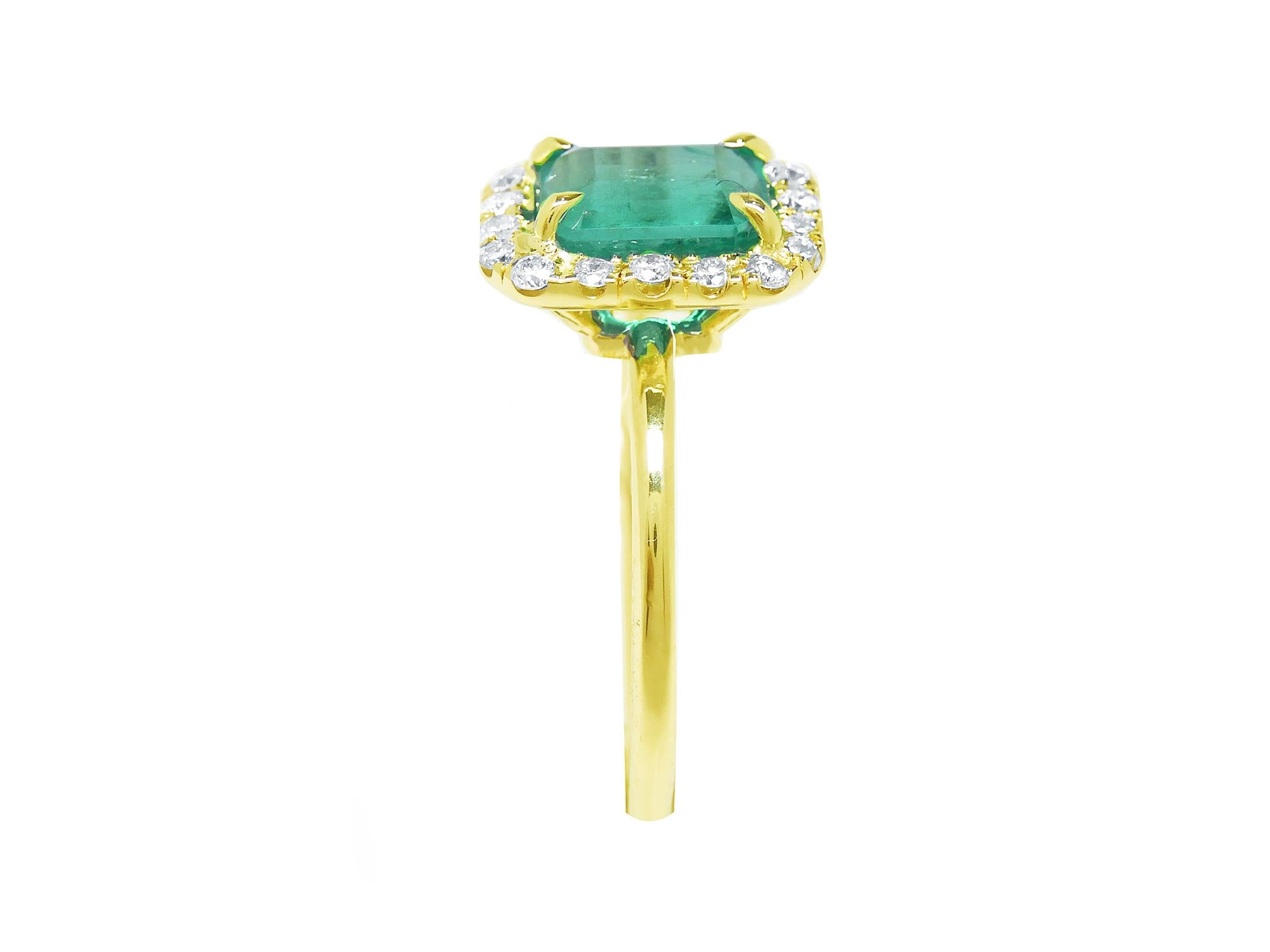 This natural emerald with a halo diamond ring is displaying the gemstone side and band profile.