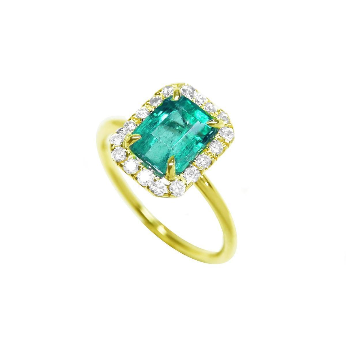 This emerald ring on a tilted position is displaying the top emerald, halo diamond and band of the ring.