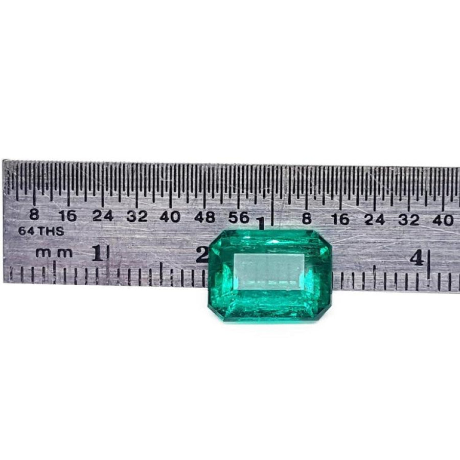 Vibrant bluish-green 4.18 carat emerald-cut loose emerald from Muzo, Colombia, next to a ruler.