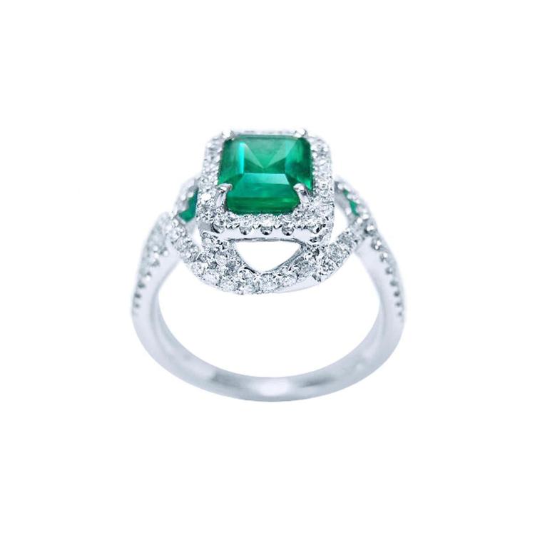 Emerald-cut Colombian emerald ring with halo diamonds in 18K white gold.