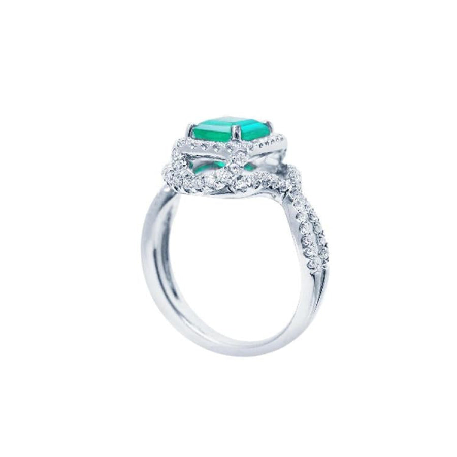 18K white gold ring with a vibrant emerald-cut emerald and sparkling halo diamonds.