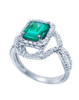 A 18k white gold natural emerald ring with accent diamonds displaying the top gemstone and side profile.