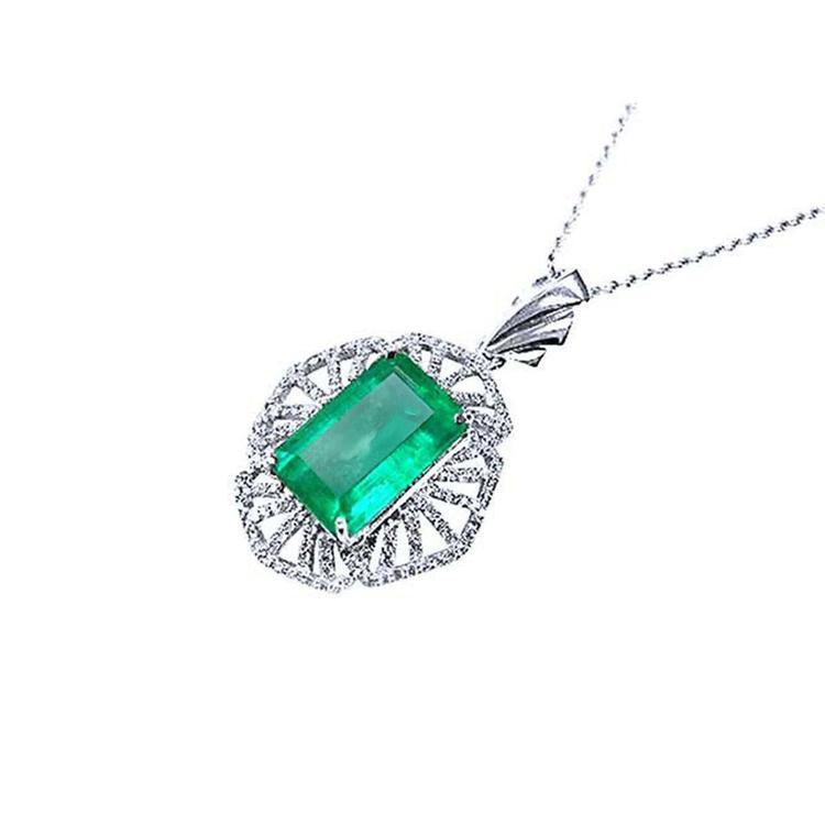 Emerald green gemstone pendant on a white background