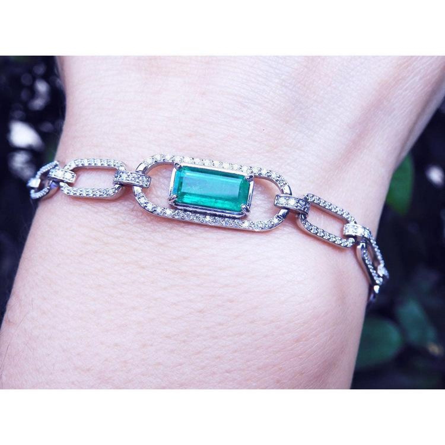14K white gold paper clip bracelet with a rectangular Colombian emerald haloed by diamonds.