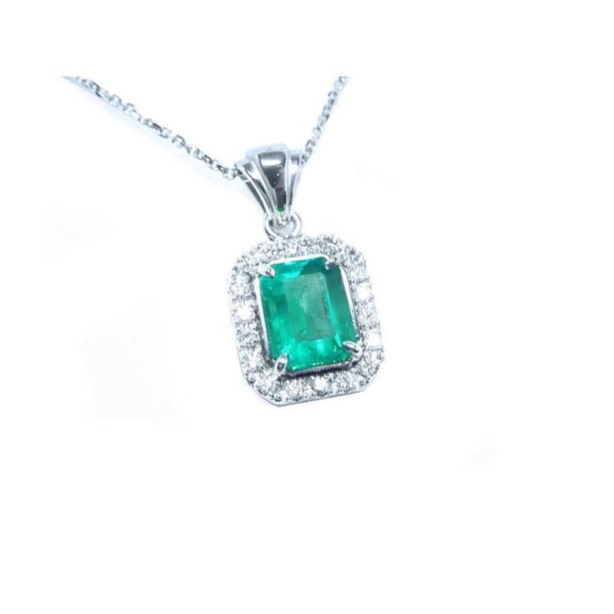 Emerald-cut emerald pendant with halo diamonds in 14K white gold on a delicate chain.