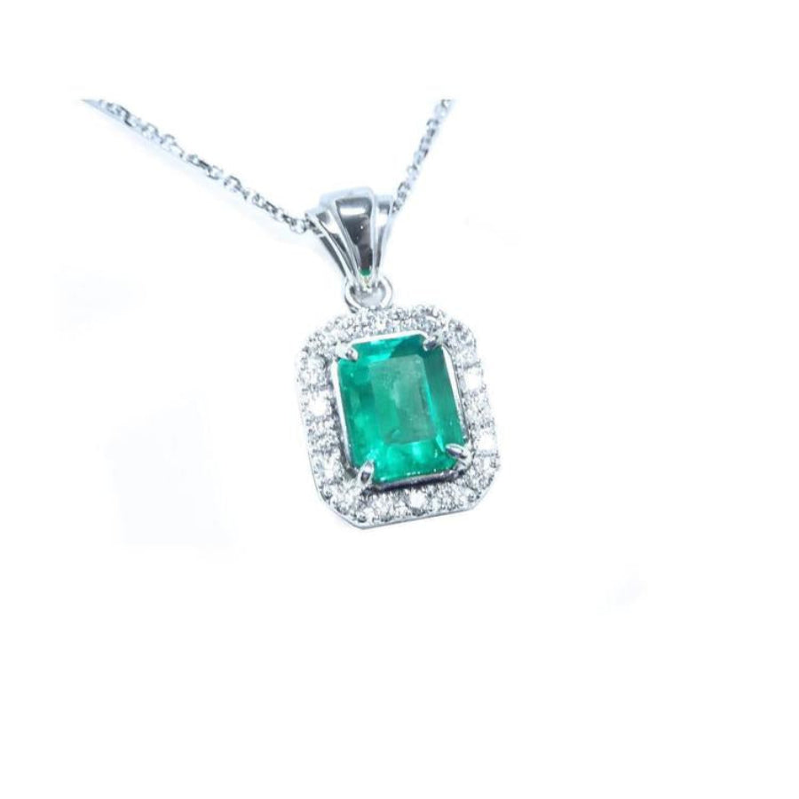Emerald-cut emerald pendant with halo diamonds in 14K white gold on a delicate chain.