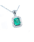 Emerald-cut emerald pendant with halo diamonds in 14K white gold on a delicate chain.