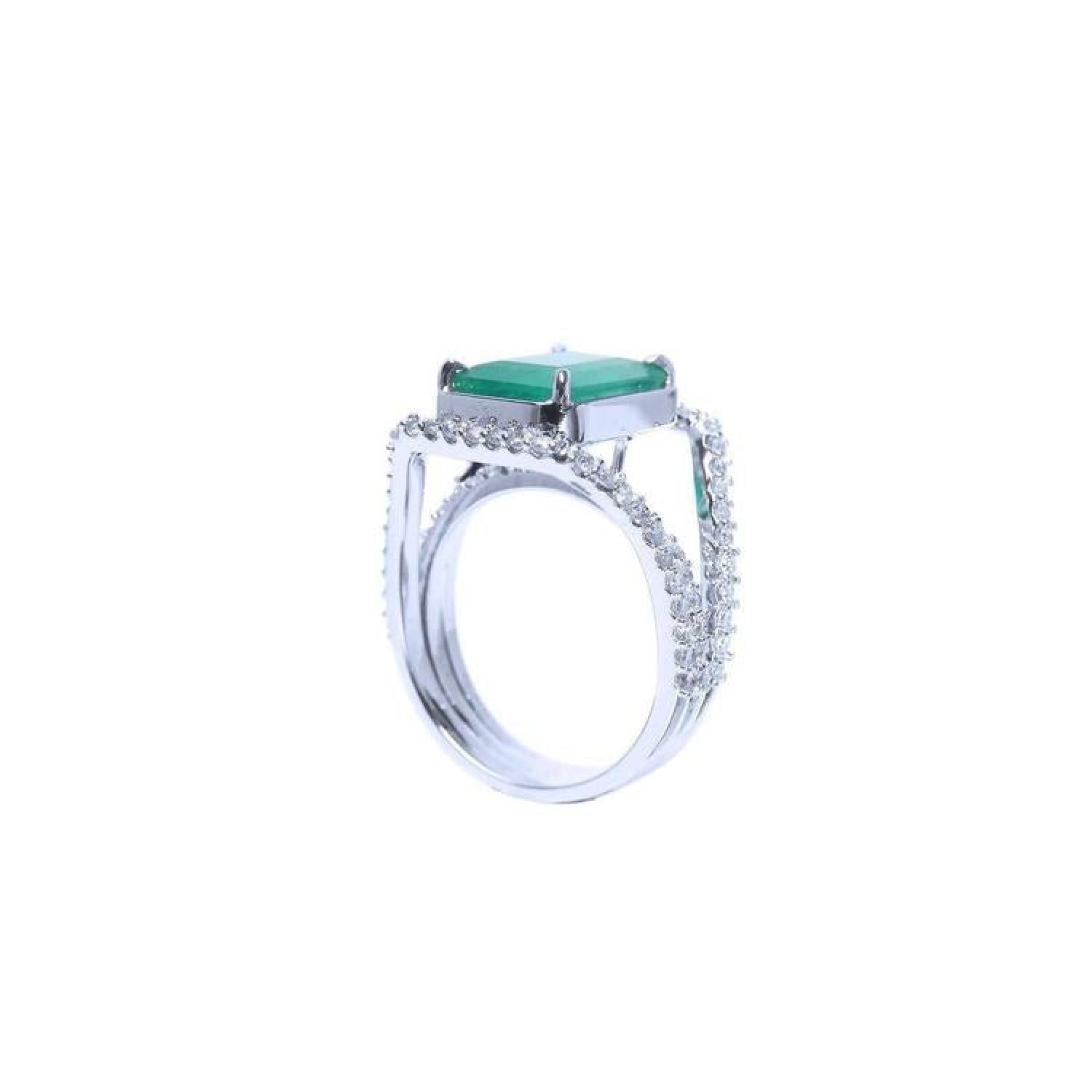 Emerald-cut 3.90 ct bluish-green emerald ring with triple diamond rows in 14K white gold.