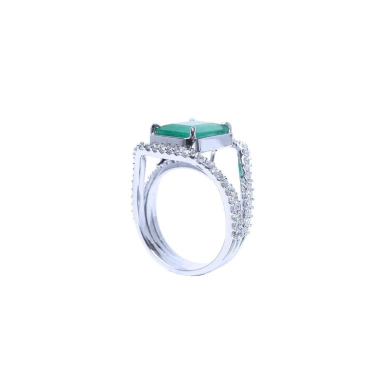 Emerald-cut 3.90 ct bluish-green emerald ring with triple diamond rows in 14K white gold.