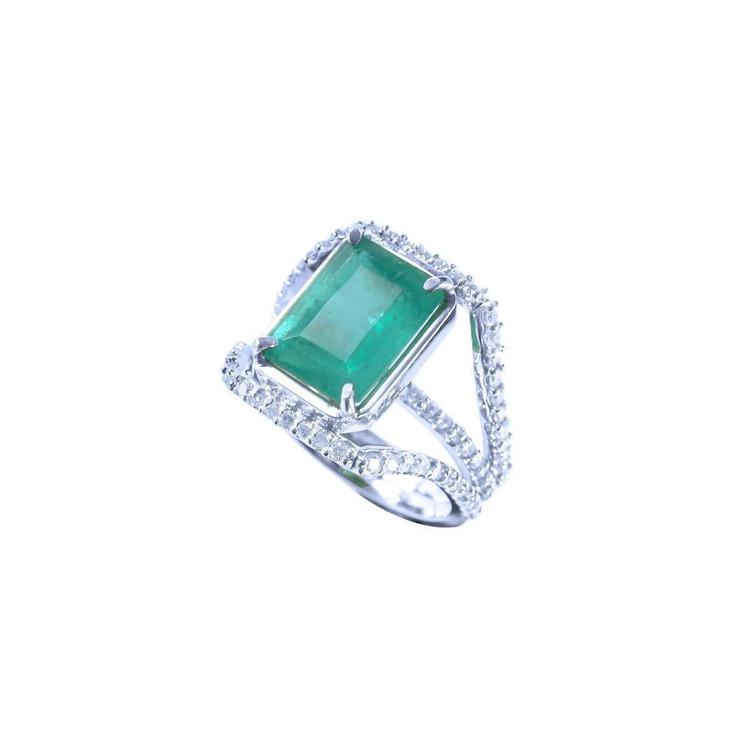 Emerald-cut 3.90 ct natural emerald ring with triple row diamond band in 14K white gold.