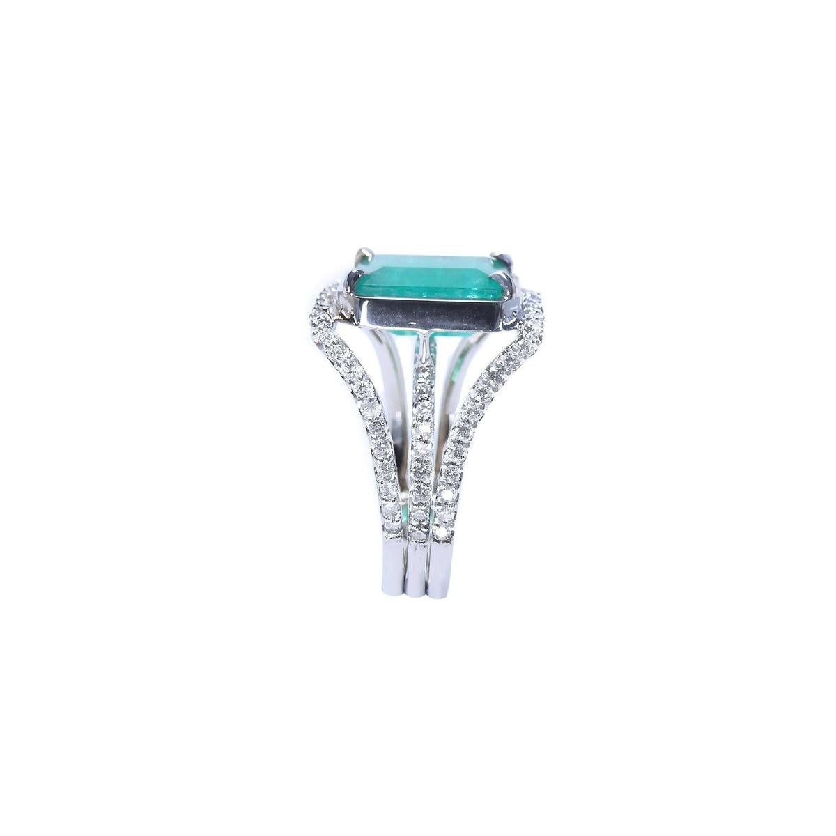 This ladies naturales emerald ring is displaying a side top and triple row of diamonds profile.