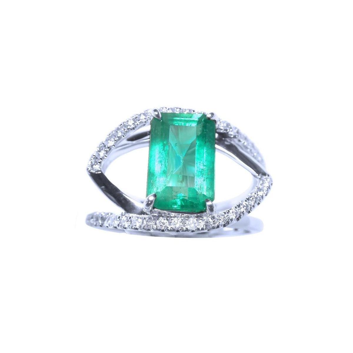 Ring with a rectangular emerald and split shank with diamonds in white gold.