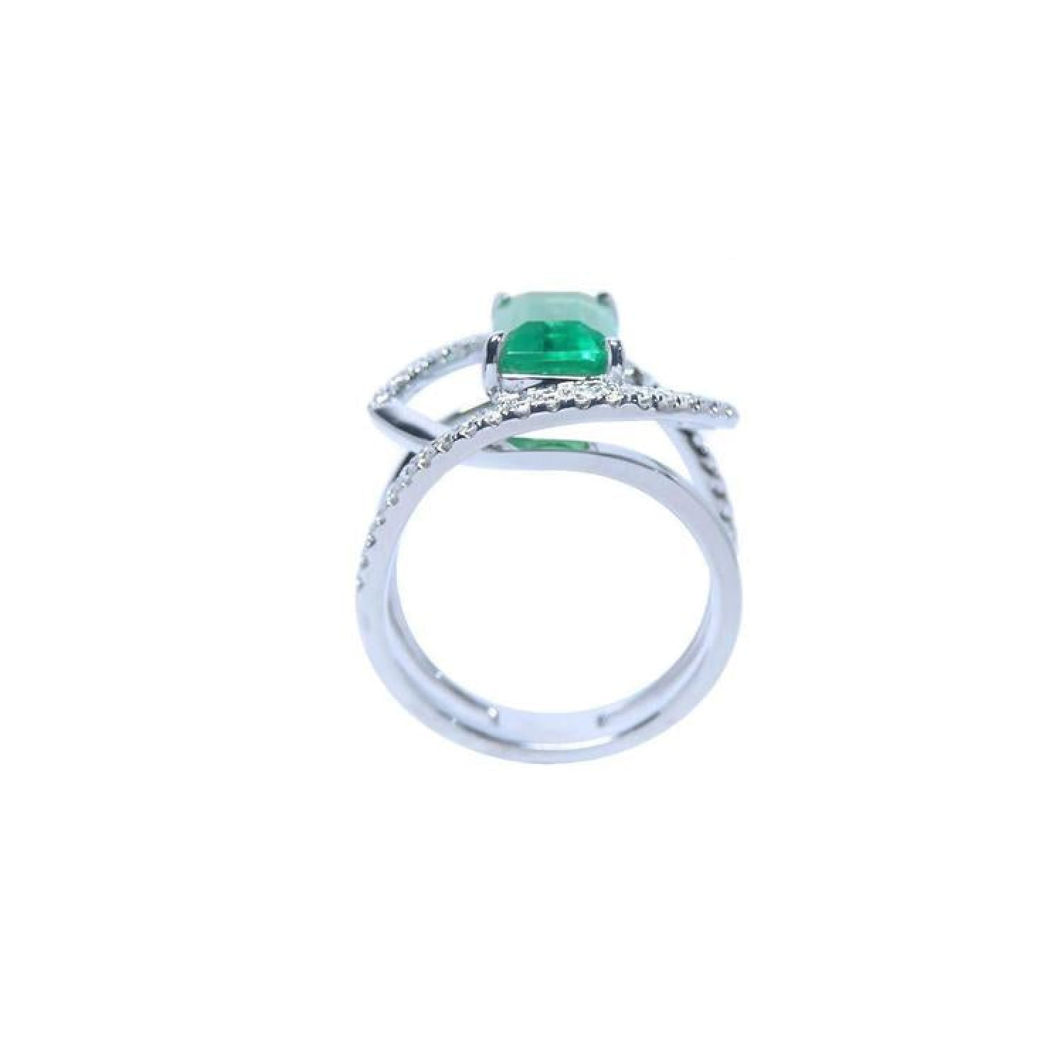 Rectangular emerald-cut emerald ring with diamond double halo and split shank in 14K white gold.