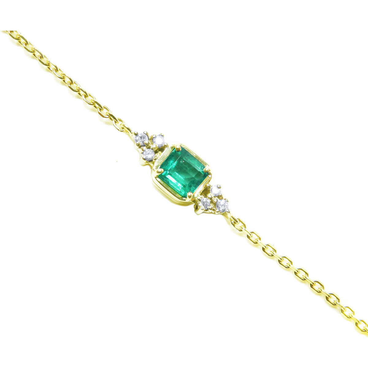 Gold bracelet with a square genuine emerald and small diamonds on a white background