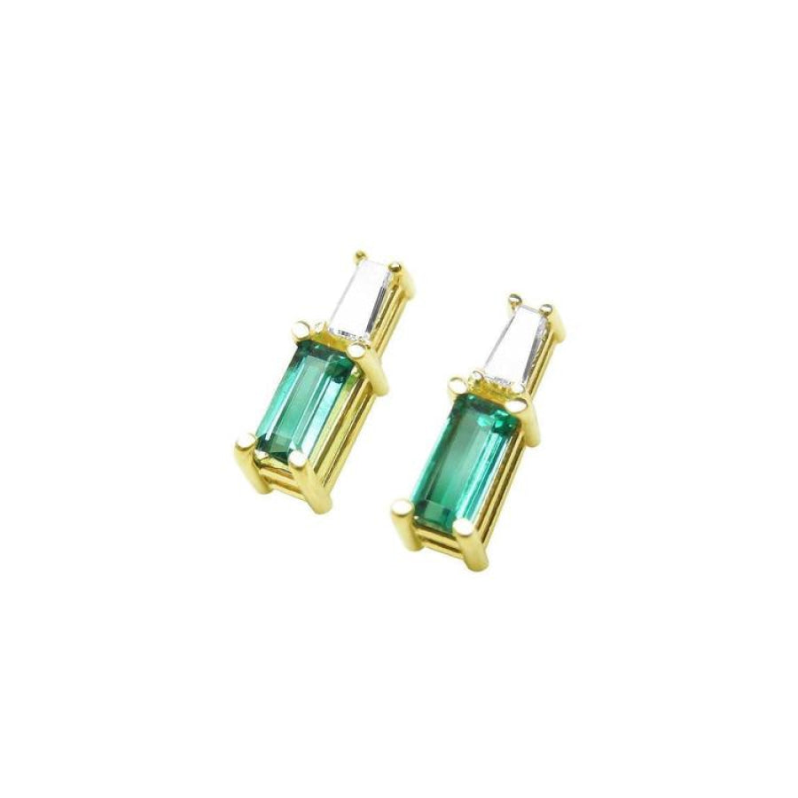 Minimalist 14K gold stud earrings with baguette emeralds and tapered diamond accents.