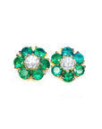 Pair of emerald and diamond stud cluster earrings on a topside view
