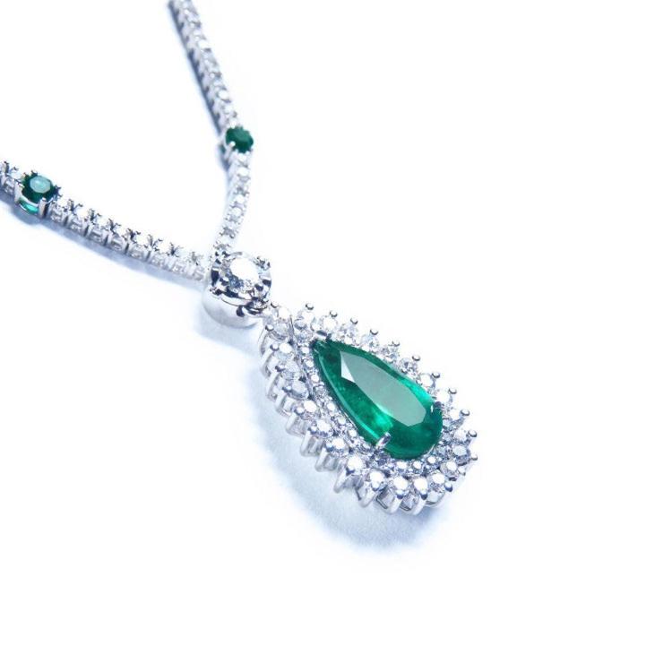 Colombian pear cut emerald necklace with a rich, deep green hue, set in 18K white gold and double halo diamonds.
