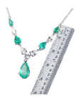 14k white gold necklace with pear-shaped emeralds and diamonds, shown with a ruler for scale.