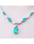 14k white gold necklace with pear-shaped emeralds and diamonds, featuring a large emerald drop pendant.