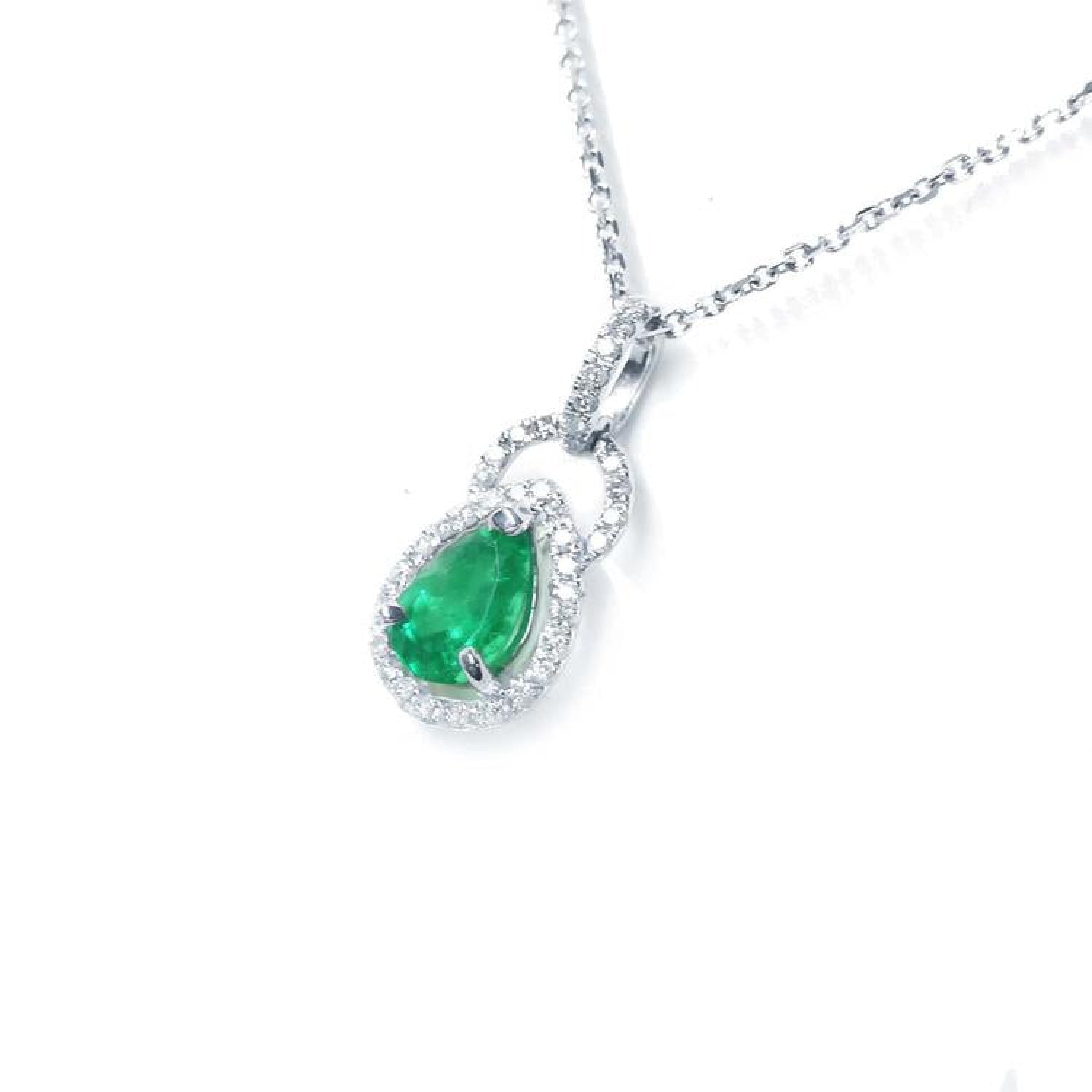 Pear-shaped Colombian emerald and diamond halo pendant in 14K white gold on a delicate chain.