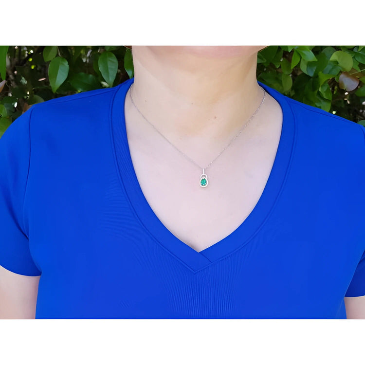 Women's emerald and diamond pendant necklace in white gold.