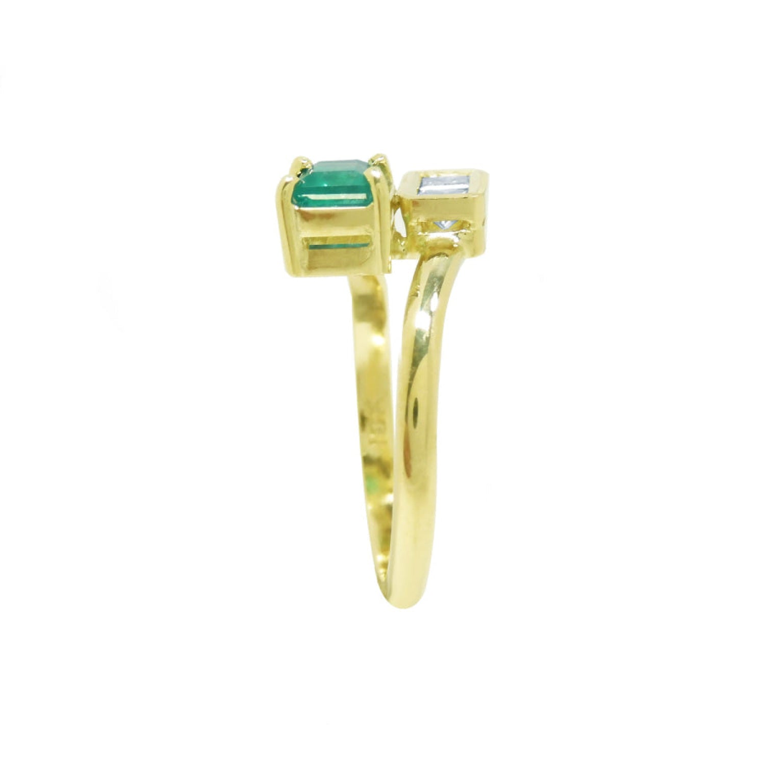 A 18k yellow gold ring featuring a rectangular emerald-cut gemstone on one side and a princess cut diamond on the other.