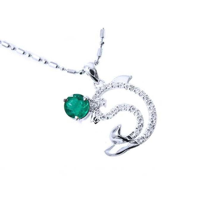 A solid white gold emerald dolphin pendant with natural diamonds.