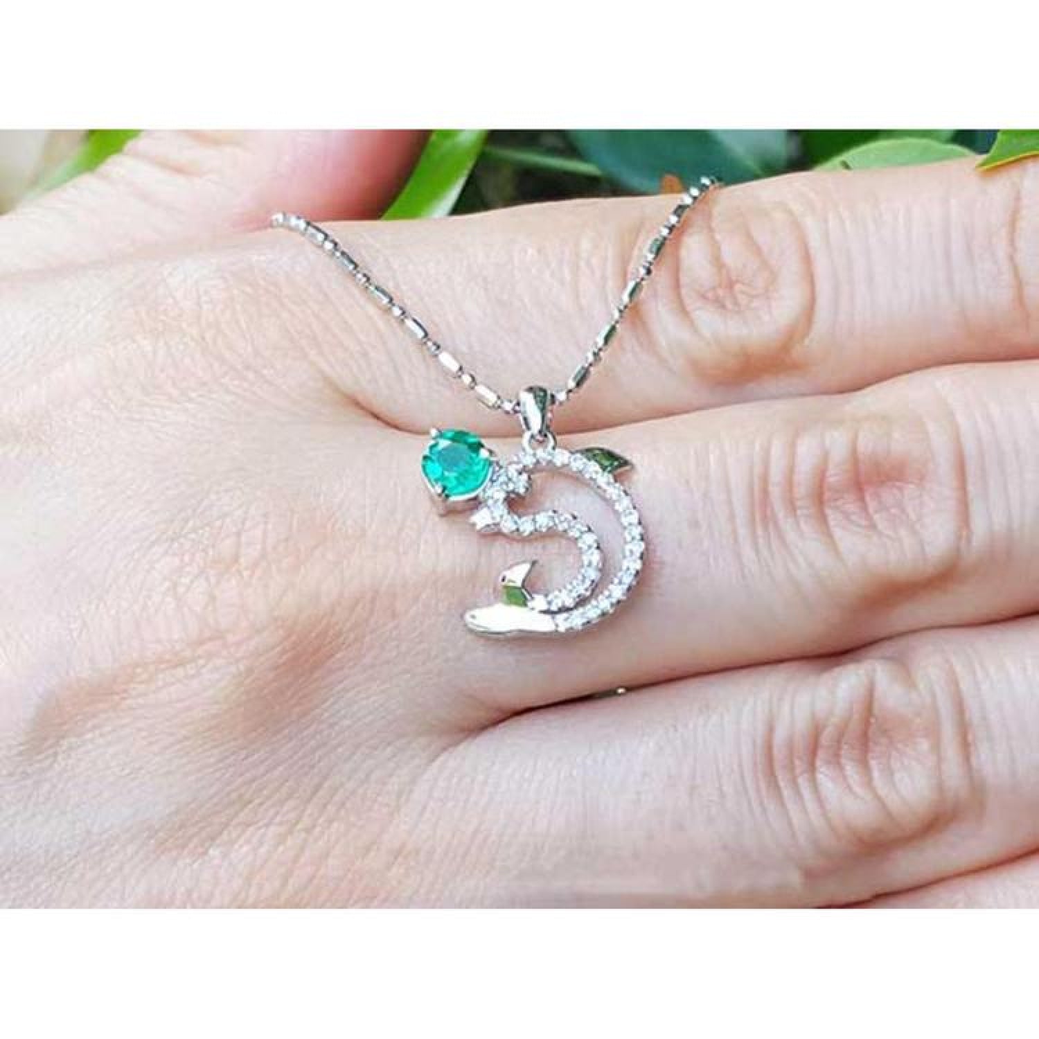 14K white gold dolphin pendant necklace with a round emerald and brilliant diamond accents.