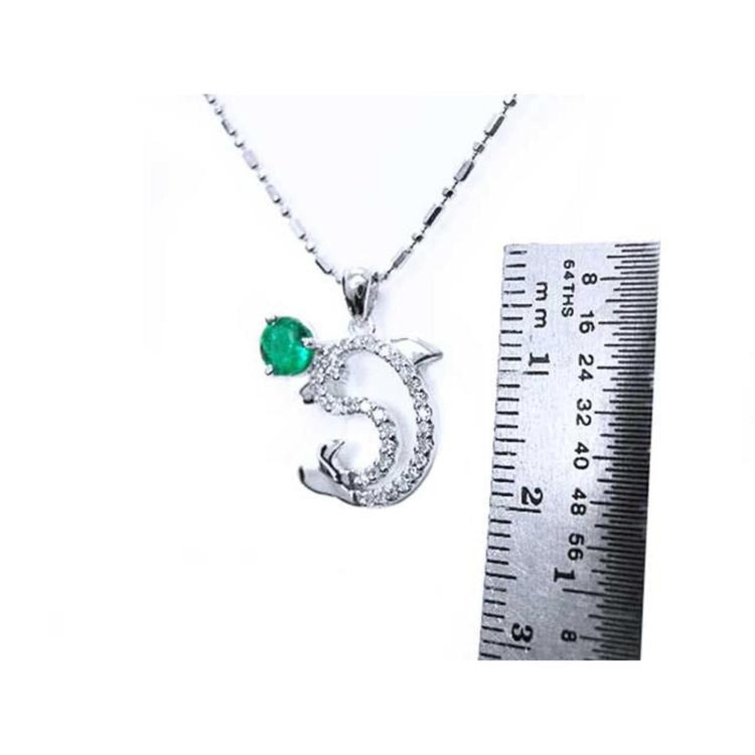 0.37 ct. emerald dolphin pendant necklace in 14K white gold, with a ruler showing its size.