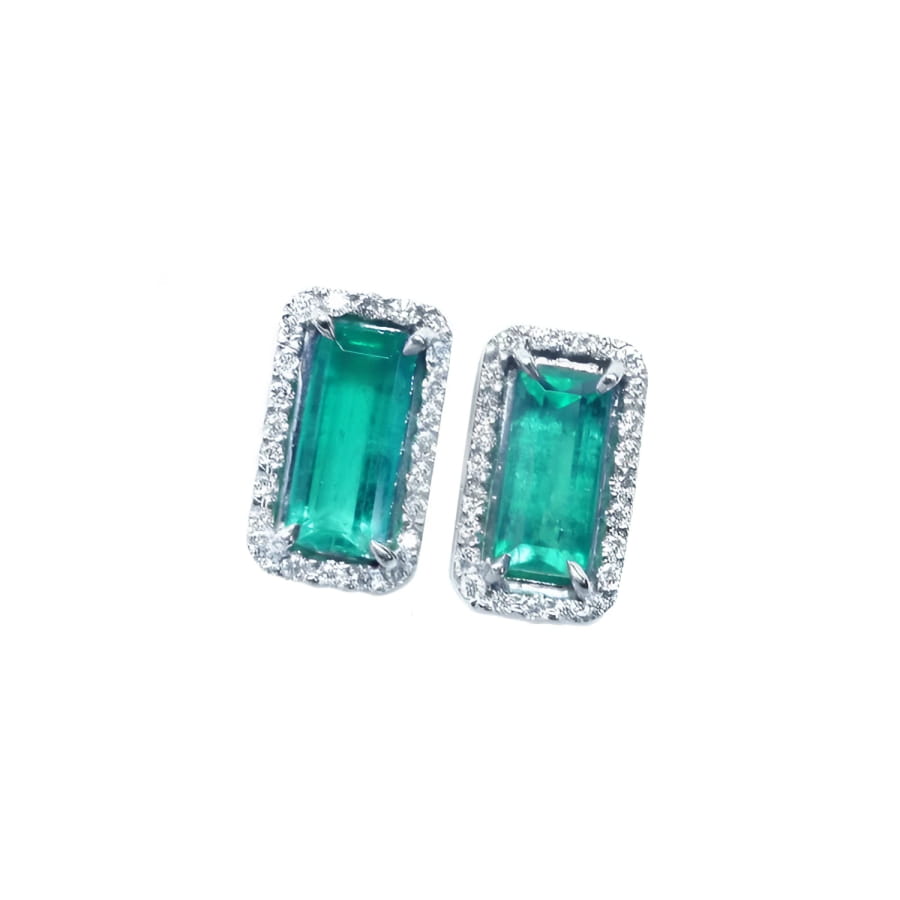 Emerald-cut Colombian emerald stud earrings with diamond halo in 18K gold.