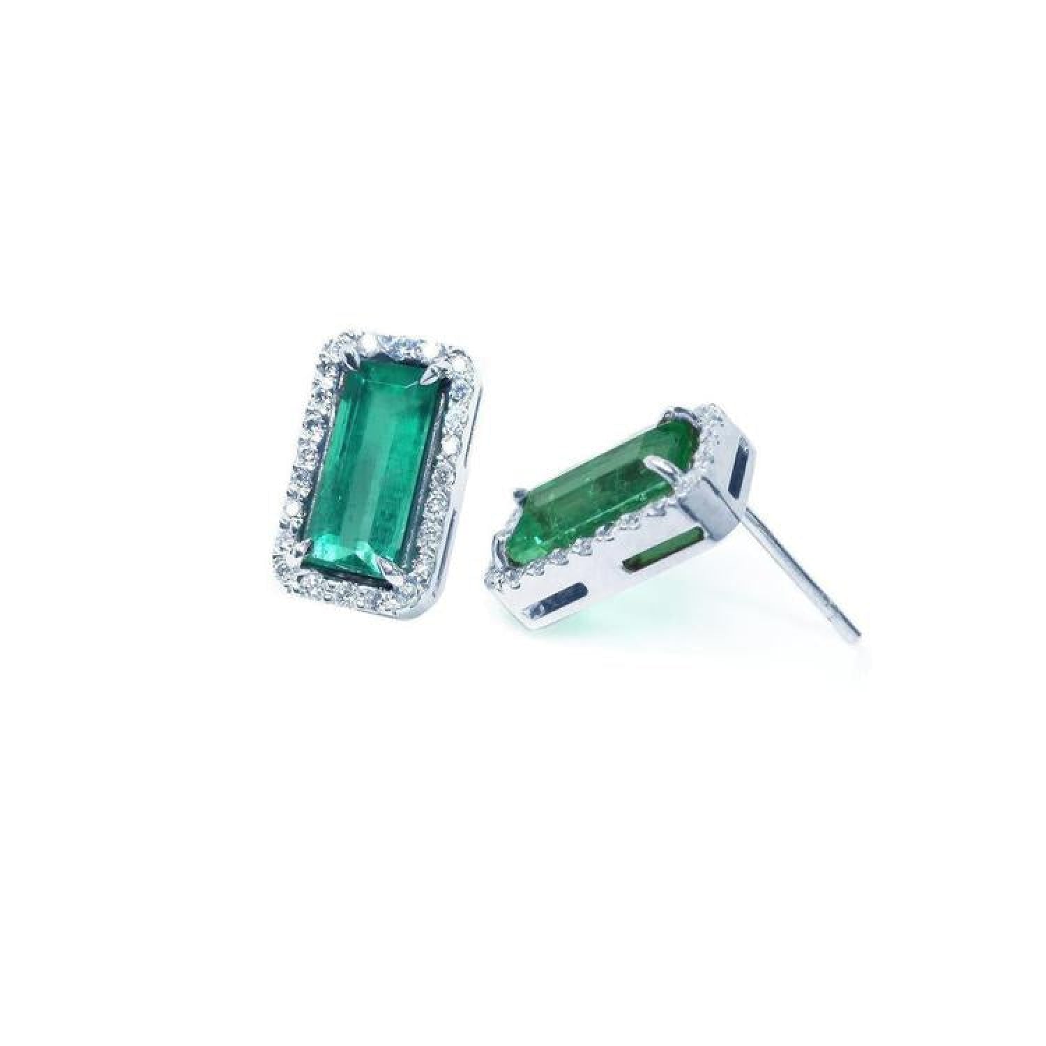 18K white gold emerald-cut stud earrings with vibrant green emeralds and diamond halos.