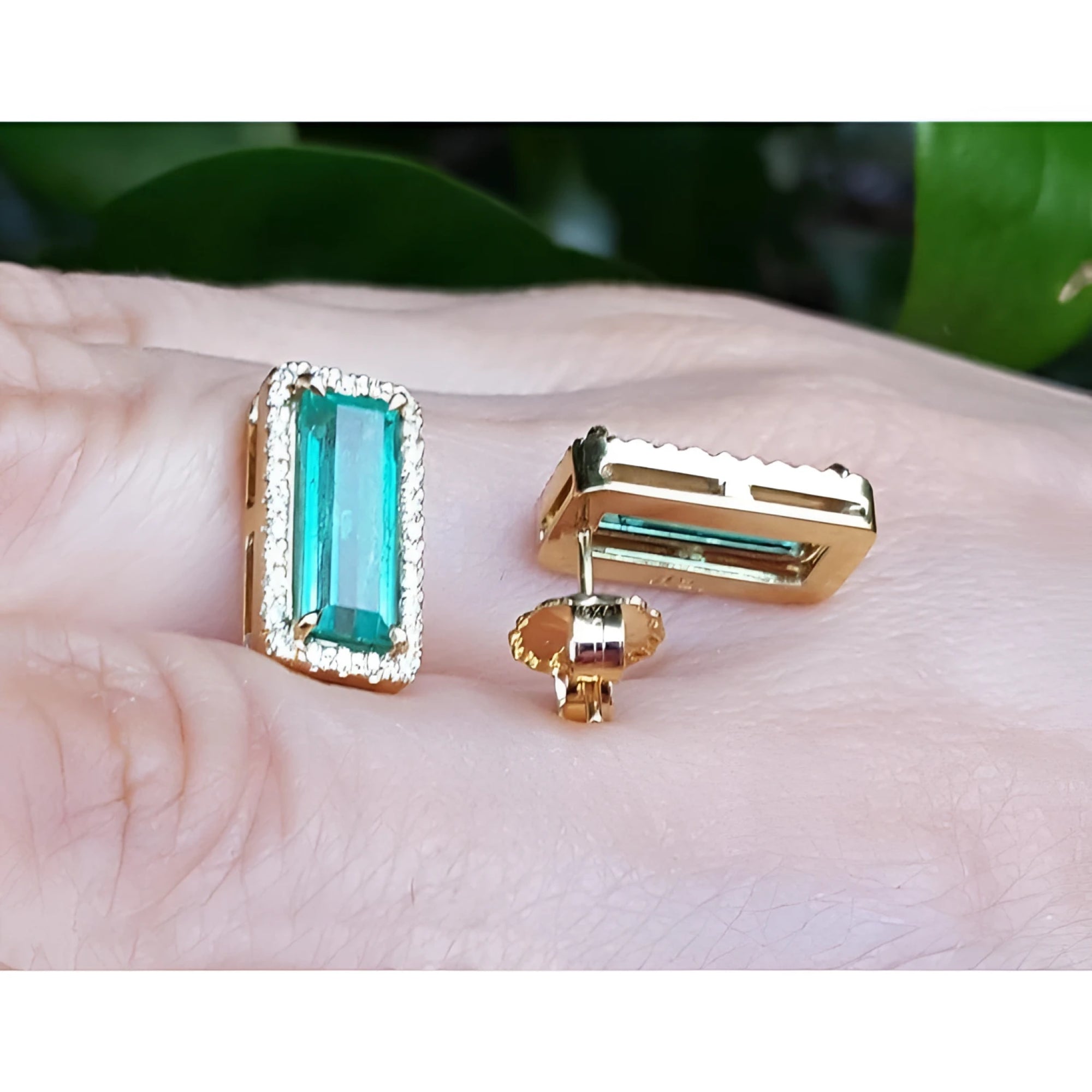Emerald-cut Colombian emerald earrings with diamond halo in 18K yellow gold.