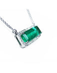 18K white gold necklace with a rectangular emerald-cut Colombian emerald and diamond halo.