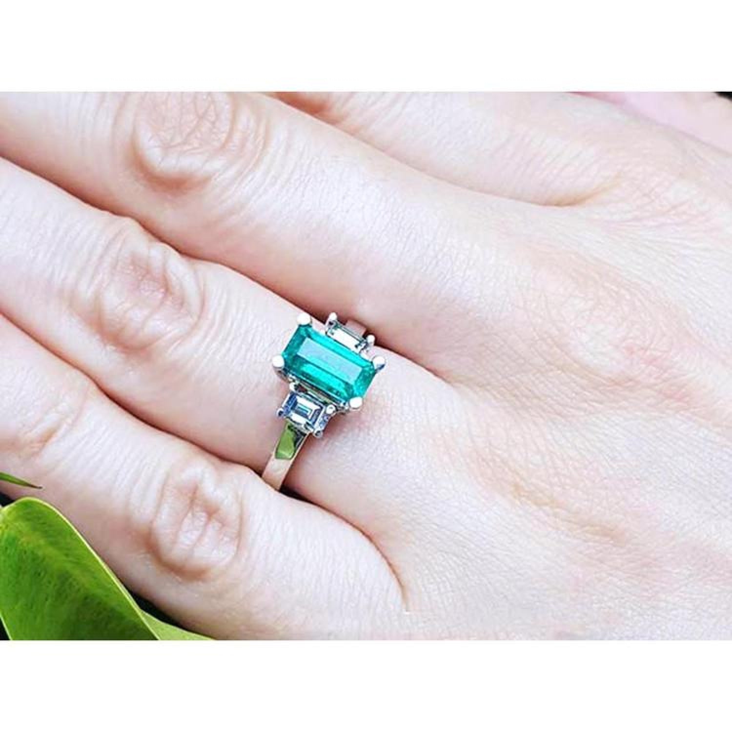 Colombian emerald engagement ring with a 1.09 ct emerald cut medium green emerald and baguette diamonds in 18K white gold.