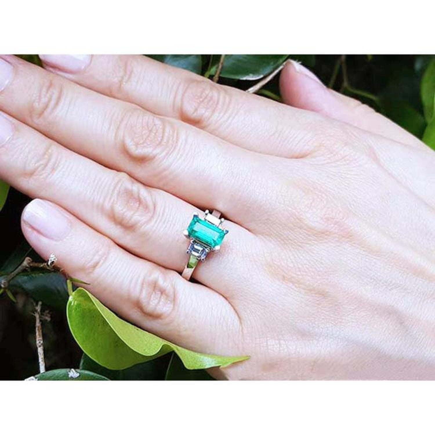 Colombian emerald engagement ring with a 1.09 ct emerald cut medium green stone and baguette diamond accents in 18K white gold.