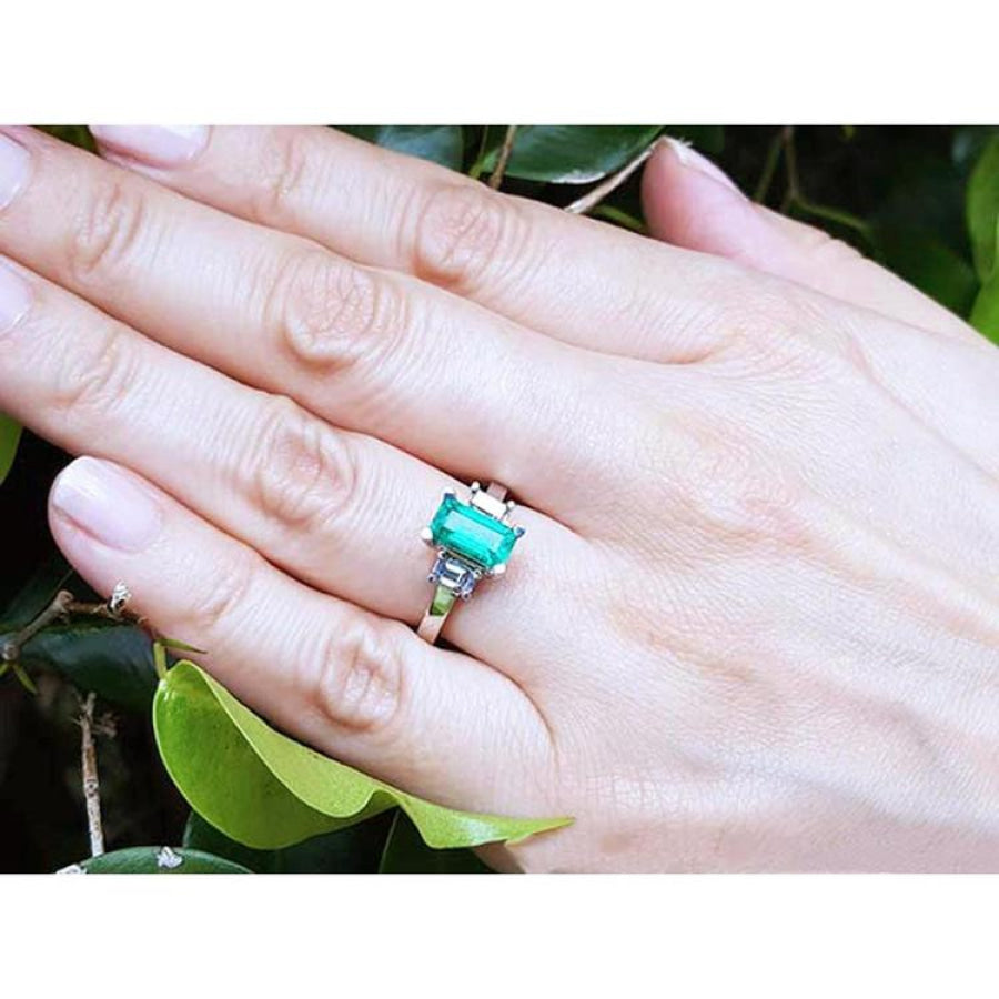Colombian emerald engagement ring with a 1.09 ct emerald cut medium green stone and baguette diamond accents in 18K white gold.