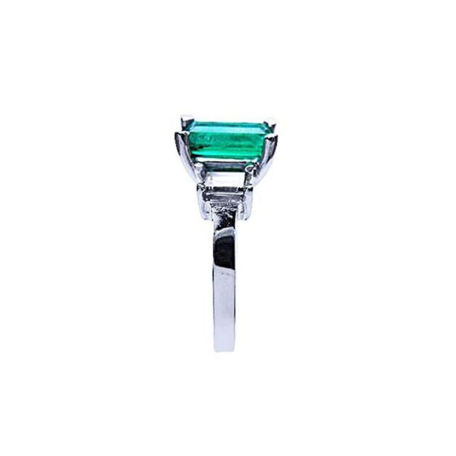 Emerald cut Colombian emerald engagement ring in 18K white gold with baguette diamond accents.