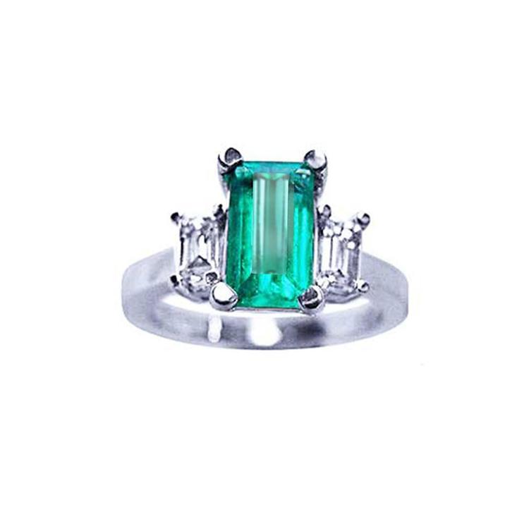 A colombian emerald three stone engagement ring side baguette diamonds made of 18k white gold.