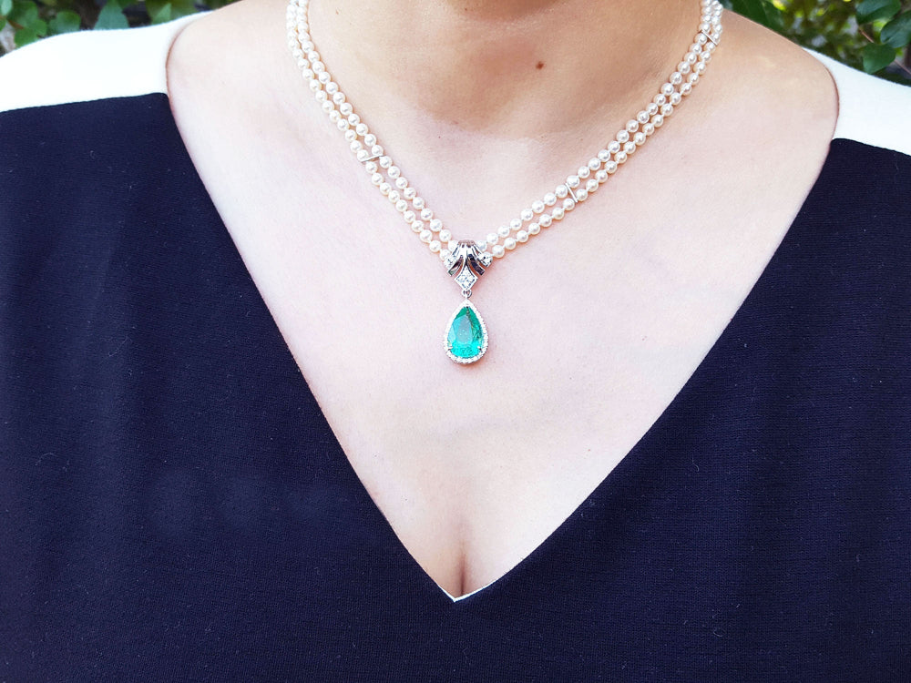 Enhancer Colombian emerald pendant pear cut medium green hue 6.01 carats encircle by a halo of natural diamonds