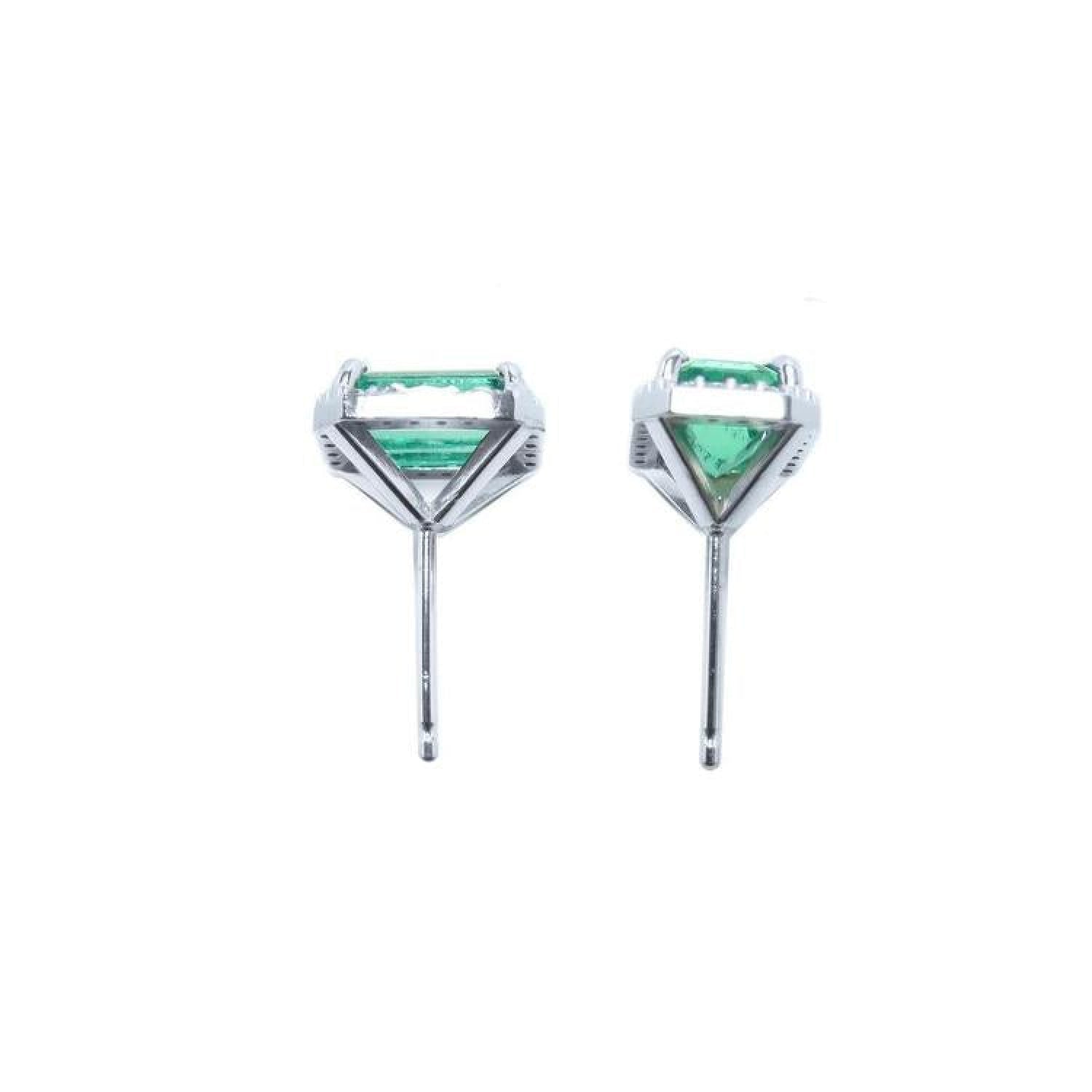 Pair of 1.74 carat emerald-cut natural emerald stud earrings with halo diamonds set in 14K gold.