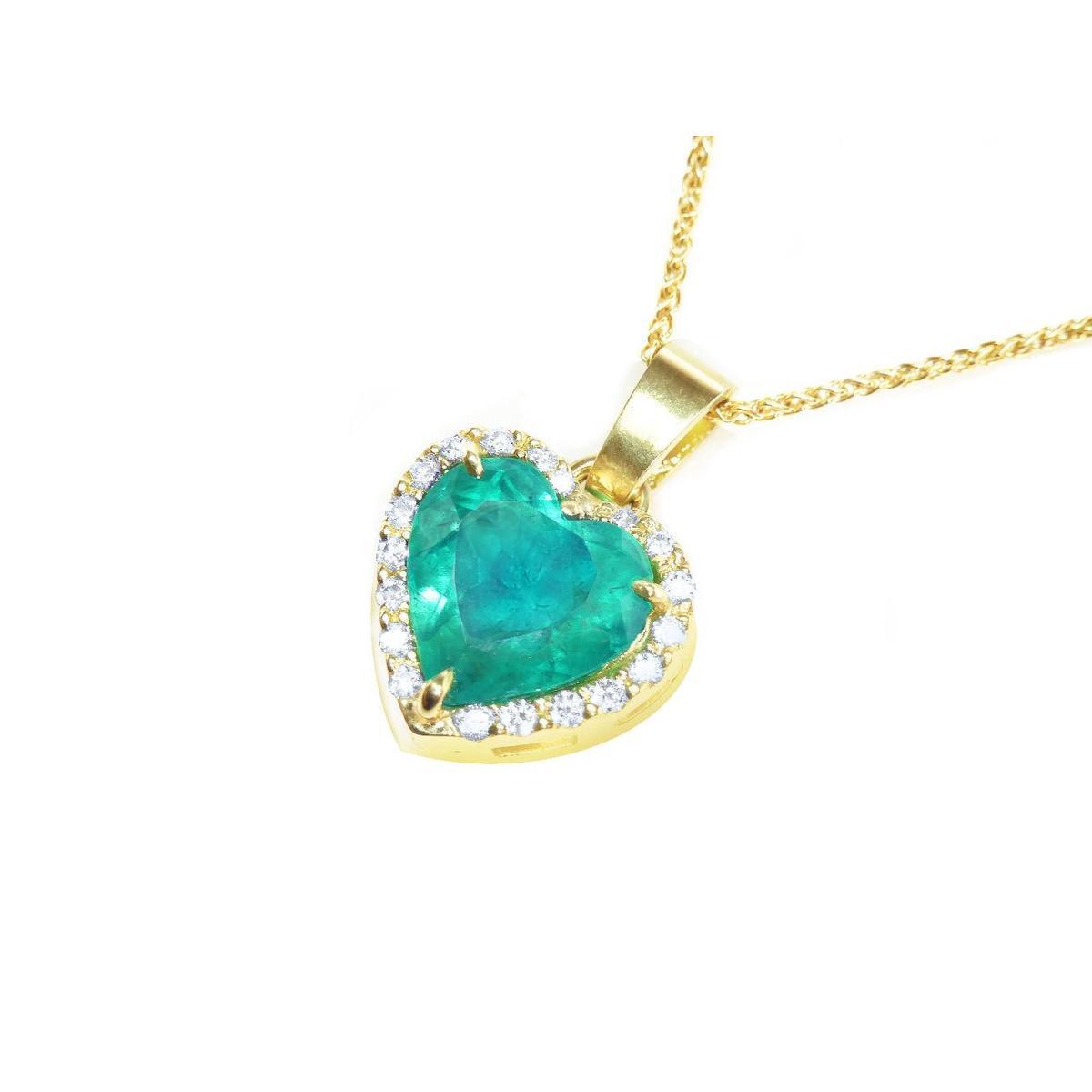 Gold necklace with a heart-shaped emerald pendant with diamonds on a side profile view.