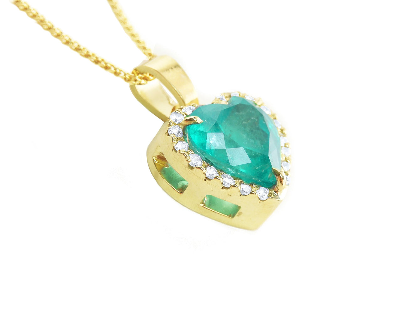 A 18k yellow gold pendant with a natural colombian emerald on a lateral side profile view.