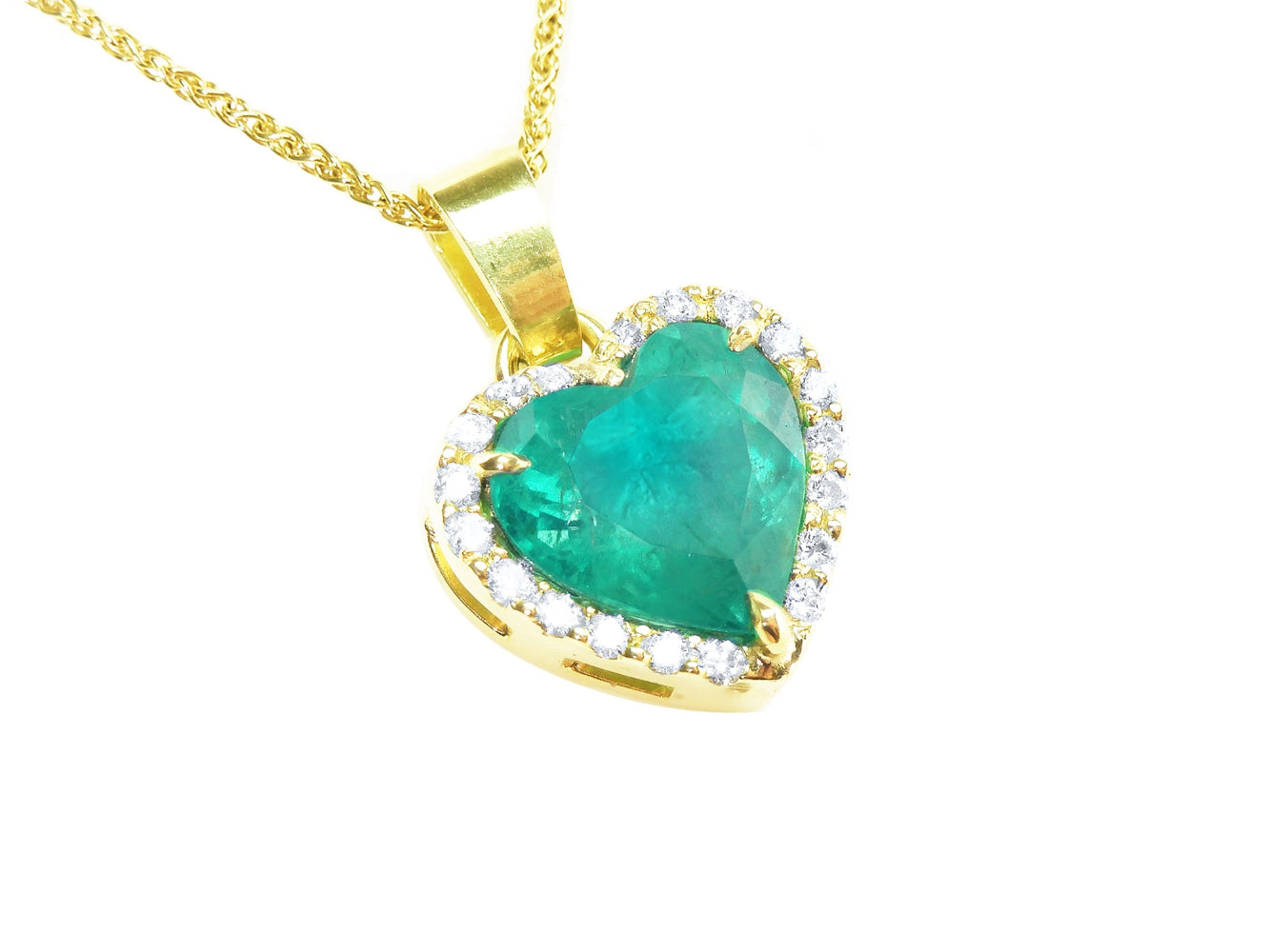 Gold necklace with a heart-shaped emerald pendant with a halo diamond on a topside view position.