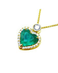 Heart-shaped emerald pendant with diamond halo and single diamond accent on an 18k gold chain.