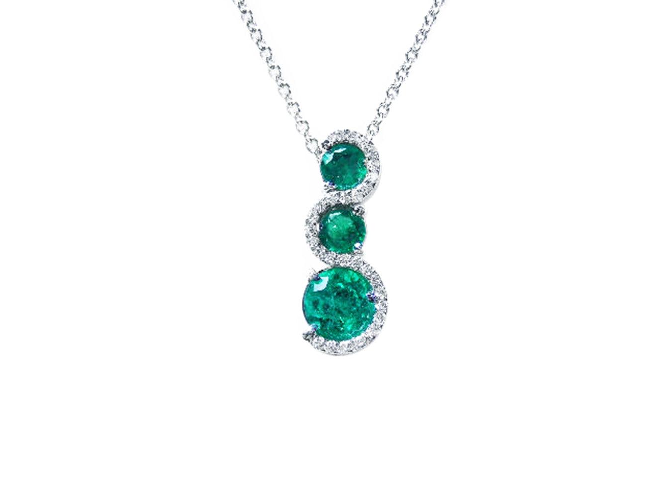 Round cut natural colombian emeralds on a journey style pendant necklace on a white gold chain topside view.