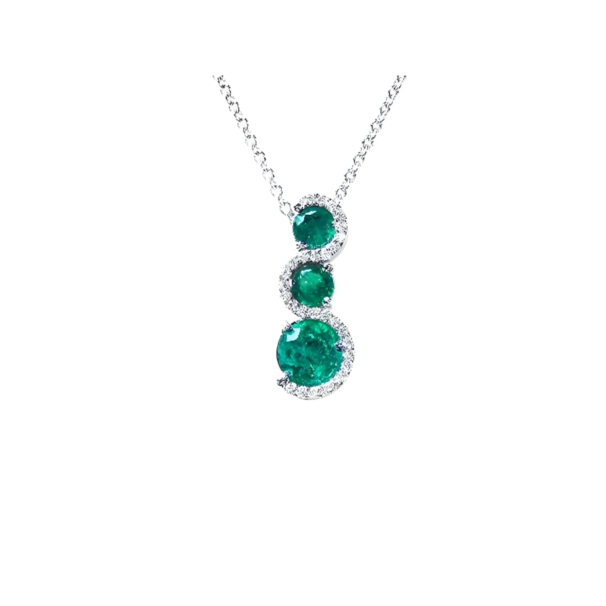 14K white gold emerald journey pendant necklace with three round, deep green emeralds encircled by diamonds.