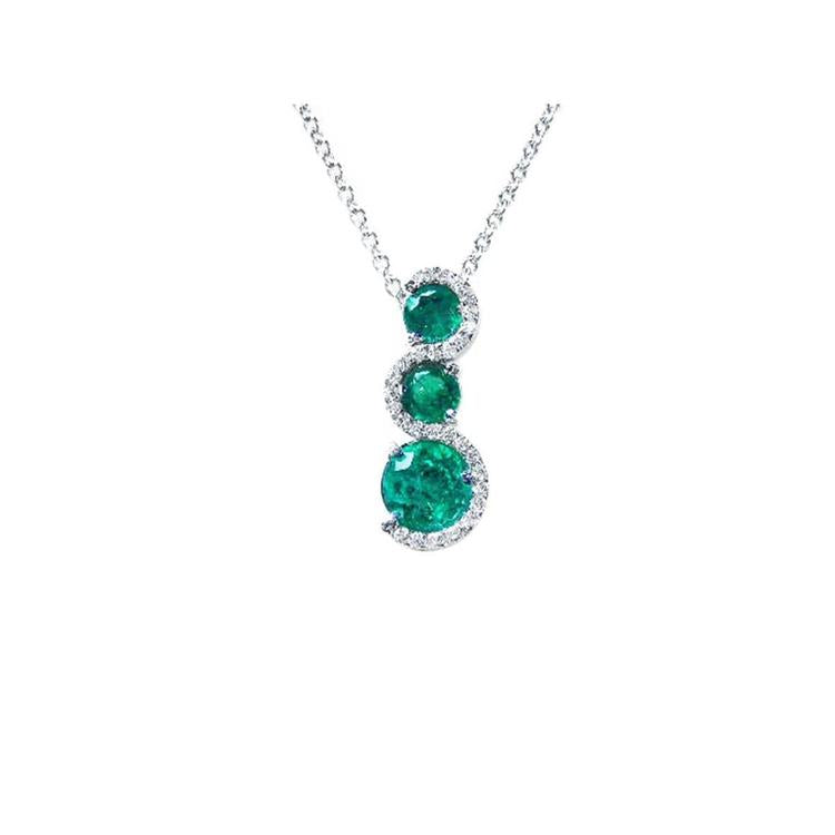 Round cut natural colombian emeralds on a journey style pendant necklace on a white gold chain topside view.